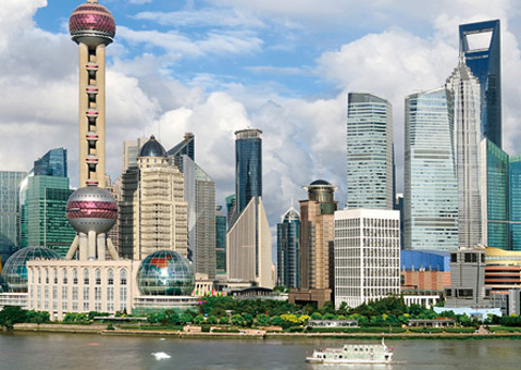 Photograph of the skyline of the Pudong district of Shanghai, China. The Huangpu River is visible in the foreground.